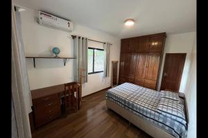 a bedroom with a bed and a desk and a window at Casa dos Pajurás - Santarém - Ponta de Pedras - Alter do chão in Alter do Chao