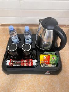 a tray with a tea kettle and some drinks at فـالـي ريزيدنـس - Valley Residence in Al Baha