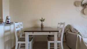 einen Tisch mit zwei Stühlen und eine Vase mit einer Pflanze darauf in der Unterkunft LOS ALTOS sea view apartment in Finestrat