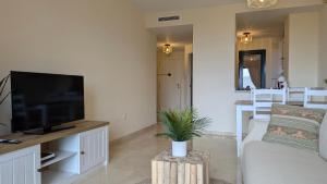 ein Wohnzimmer mit Fernseher und Sofa in der Unterkunft LOS ALTOS sea view apartment in Finestrat