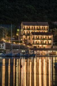 a large building next to a marina at night at Sivota Bay in Sivota