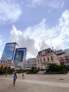 a group of people walking in a city with buildings at Appartement cosy Paris in Bagnolet +7 photos