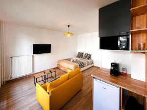 a living room with a yellow couch and a tv at Appartement cosy Paris in Bagnolet