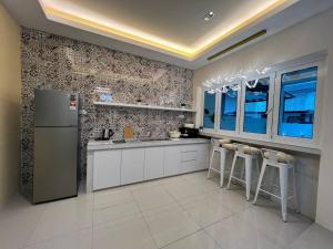 a kitchen with a refrigerator and some bar stools at jia Residence 21 pax Karaoke & Snooker in Ipoh