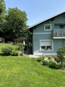 a blue house with a balcony and a yard at LizMari in Podčetrtek
