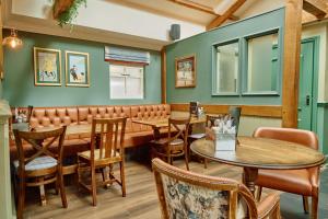 a restaurant with wooden tables and chairs and green walls at The Pennine Inn in Kirkby Stephen +25 photos