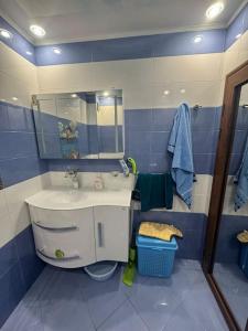 a blue and white bathroom with a sink and a mirror at Sunny & Stylish Apartment in Vratsa +17 photos