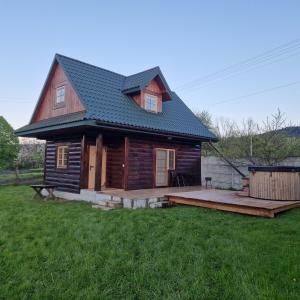 a log cabin with a deck in a yard at Serce Beskidu Niskiego in Świątkowa Mała