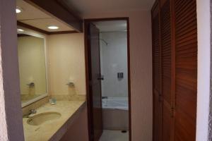 y baño con lavabo, ducha y bañera. en Hacienda del Mar Resort Condominio 205, en Cancún