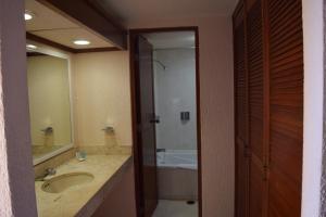 a bathroom with a sink and a shower and a tub at Hacienda del Mar Resort Condominio 205 in Cancún