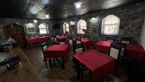 a restaurant with red tables and chairs in a room at Stonehouse villa in Valbonë