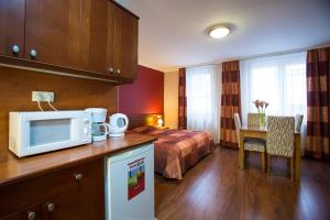 a hotel room with a bed and a table with a microwave at City Home Budapest in Budapest