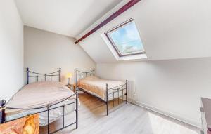 two beds in a attic bedroom with a window at 3 Bedroom Awesome Home In Jaulgonne in Jaulgonne