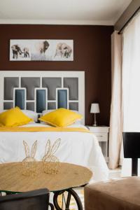 a bedroom with a bed with yellow and blue pillows at If Not Why Not Guesthouse in Potchefstroom