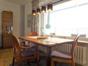 una cucina con tavolo e sedie in legno e una finestra di Atlantischer Hof 29, Königstraße a Wyk auf Föhr