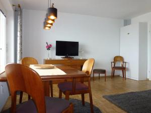 una sala da pranzo con tavolo, sedie e televisione di Atlantischer Hof 29, Königstraße a Wyk auf Föhr