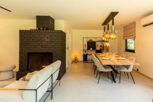 a dining room with a fireplace and a table and chairs at La Cabane d'Amae in Marche-en-Famenne