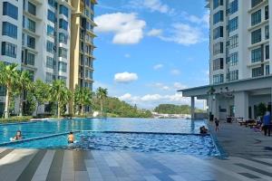 une piscine au milieu de deux grands bâtiments dans l'établissement HOME SWEET HOME ARC AUSTIN HILLS 4-6pax, à Johor Bahru