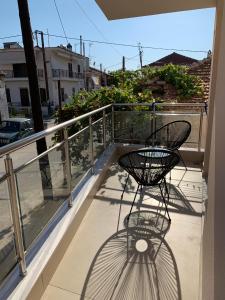 a metal chair on a balcony with a view of a street at Milto's Apartment in Limenaria