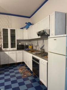 a kitchen with white cabinets and a checkered floor at Naxos Beach House in Giardini Naxos
