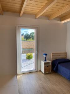 a bedroom with a bed and a sliding glass door at La casa nel verde in Recanati