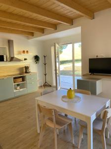 a kitchen and dining room with a white table and chairs at La casa nel verde in Recanati