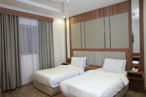 Postel nebo postele na pokoji v ubytování Buyot Malath Serviced Apartment - شقق بيوت ملاذ للشقق المخدومة
