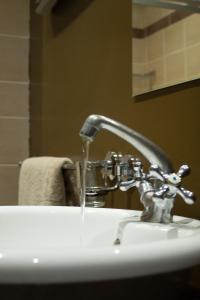 a bathroom sink with water running from a faucet at If Not Why Not Guesthouse in Potchefstroom +19 photos