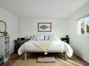 Un dormitorio blanco con una cama y un escritorio. en Baywood Casita- kids, dogs, hot tub, en Baywood Park