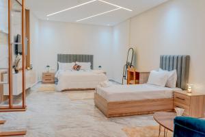 a bedroom with two beds and a mirror at Blue Vista Hotel in Dakhla