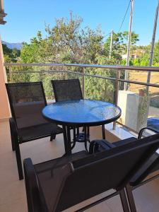 a table and chairs on a balcony with a view at Milto's Apartment in Limenaria