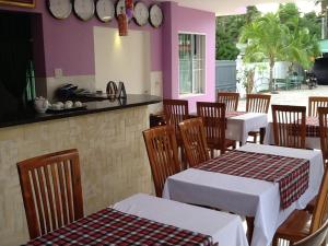 un ristorante con tavoli e sedie bianchi e un bancone di Areca Resort a Mui Ne