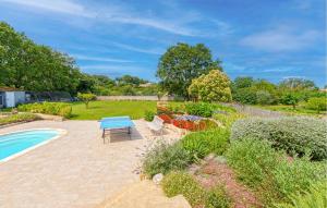 eine Terrasse mit einem blauen Tisch und Stühlen neben einem Garten in der Unterkunft Cozy Home In Aubarne Santanastasie in Sainte Anastasie - Aubarne