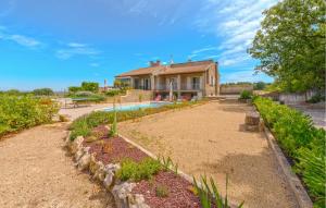 ein Haus mit einem Swimmingpool vor einem Garten in der Unterkunft Cozy Home In Aubarne Santanastasie in Sainte Anastasie - Aubarne + 12 Fotos