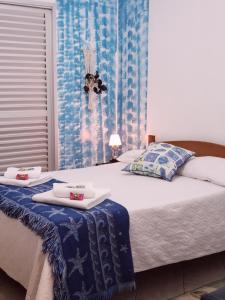 a bedroom with a bed with two towels on it at La Linda Playa in Guaratuba