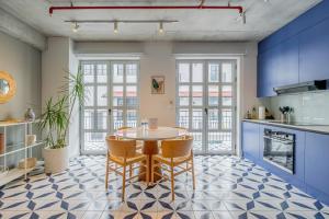 a kitchen with a table and chairs and blue cabinets at Casa Contemporánea by Wynwood House in Panama City