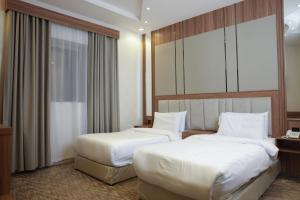 Postel nebo postele na pokoji v ubytování Buyot Malath Serviced Apartment - شقق بيوت ملاذ للشقق المخدومة