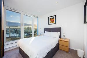 a bedroom with a bed and a large window at Austin David Executive ExCeL in London