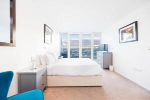 a white bedroom with a bed and a window at Austin David Executive ExCeL in London