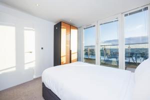 a bedroom with a bed and a large window at Austin David Executive ExCeL in London