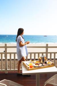 a woman standing next to a table with a tray of food at Grand Hôtel Perros-Guirec in Perros-Guirec