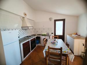 eine Küche mit einem Tisch und einem weißen Kühlschrank in der Unterkunft Villa del Poggio Marina di Camerota in Lentiscosa