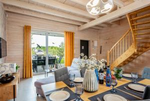 a living room with a table and a dining room at Domki Asgard in Gąski