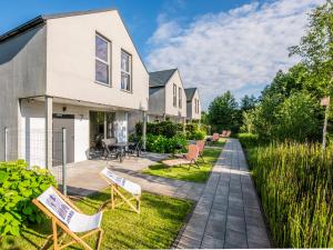 a house with chairs and a patio at Domki Asgard in Gąski