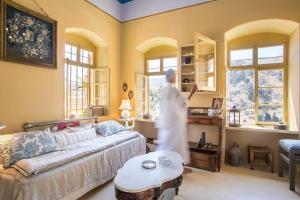 a woman is standing in a living room at kalosymi house, traditionelles haus mit hafenblick in Symi