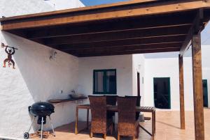 a pavilion with a table and chairs on a patio at Casita Volcan Lanzarote in Ye