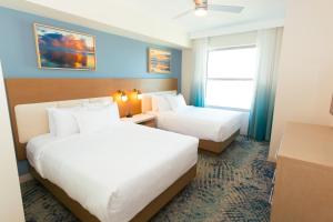 a hotel room with two beds and a window at Holiday Inn Club Vacations Myrtle Beach Oceanfront in Myrtle Beach