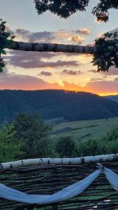 a hammock with the sunset in the background at Odaia Bunicilor in Feldru