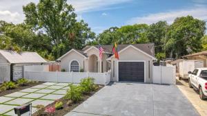ein Haus mit einem weißen Zaun und einer Auffahrt in der Unterkunft Luxury Style townhome with Pool - 1 Miles to Bucs Stadium in Tampa