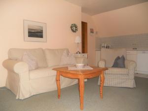 a living room with a couch and a coffee table at Haus Arfsten "Schimmelreiter", Nieblum in Nieblum